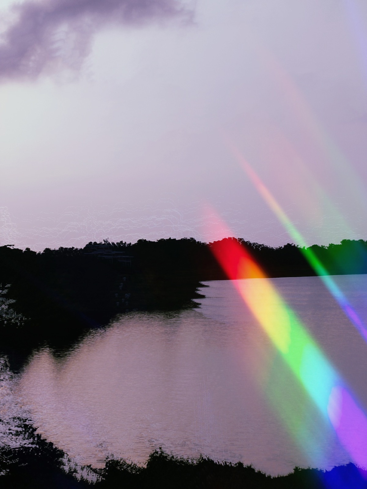 Rainbow light leak across a lake